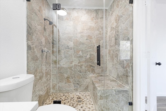 bathroom featuring walk in shower, hardwood / wood-style flooring, and toilet