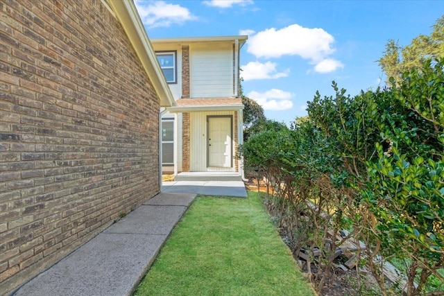 view of exterior entry with a lawn