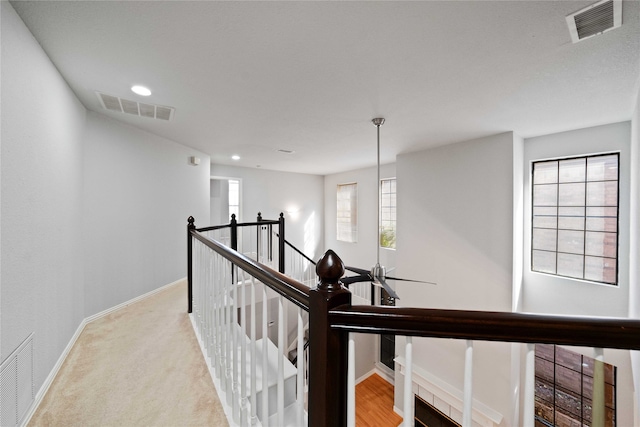 corridor featuring light colored carpet