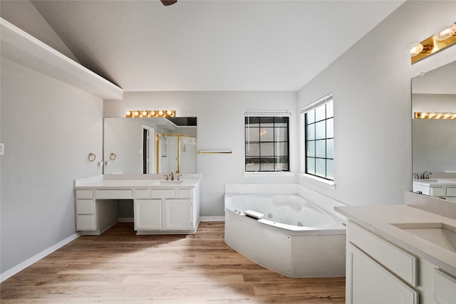 bathroom with lofted ceiling, vanity, hardwood / wood-style floors, and a tub