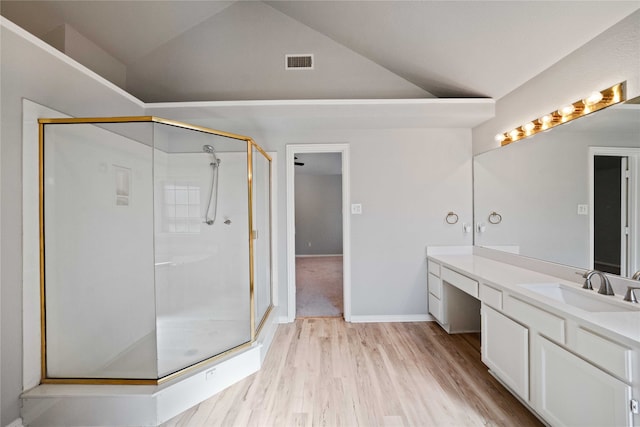 bathroom featuring walk in shower, lofted ceiling, vanity, and hardwood / wood-style flooring