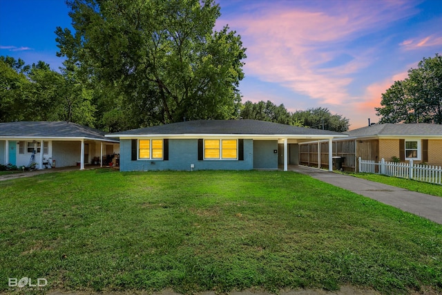 ranch-style house with a carport and a yard