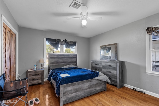 bedroom with ceiling fan, a closet, and wood-type flooring