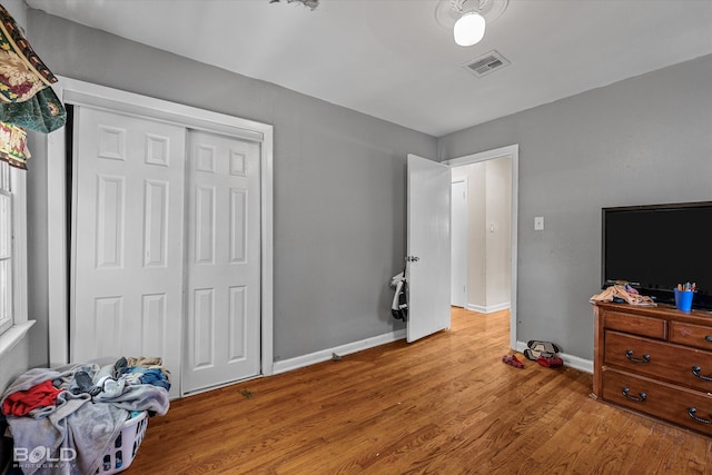 bedroom with light hardwood / wood-style floors and a closet