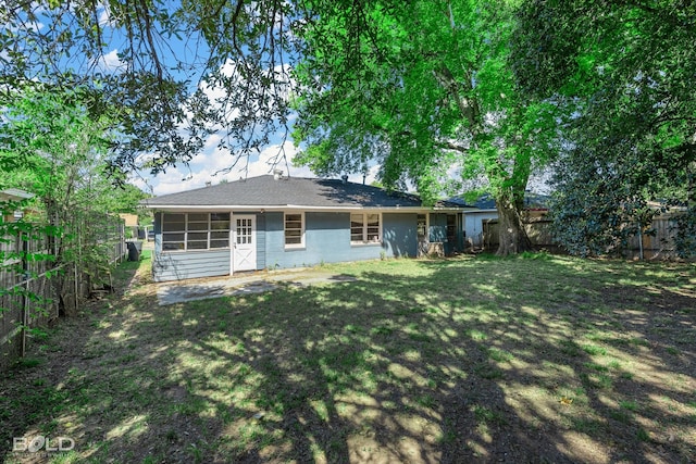 back of house with a lawn and a sunroom