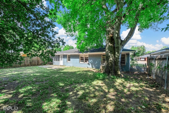 rear view of house featuring a lawn