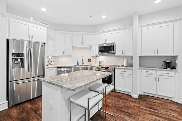 kitchen featuring stainless steel appliances, white cabinetry, and dark hardwood / wood-style floors