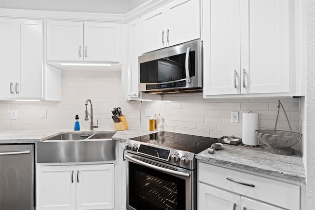 kitchen featuring white cabinets, appliances with stainless steel finishes, decorative backsplash, and sink