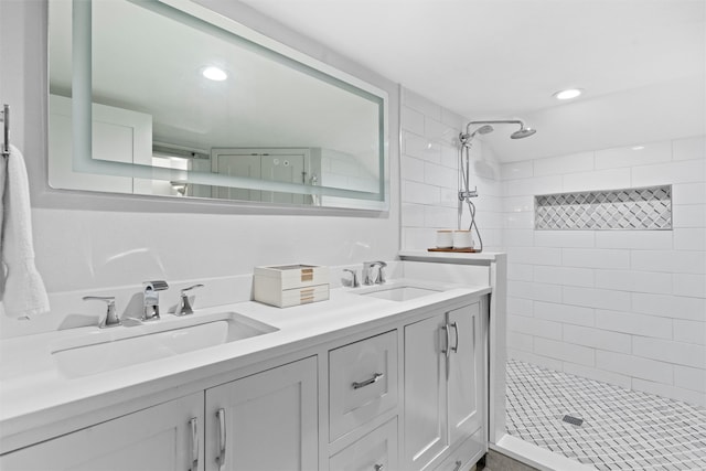 bathroom with tiled shower and vanity