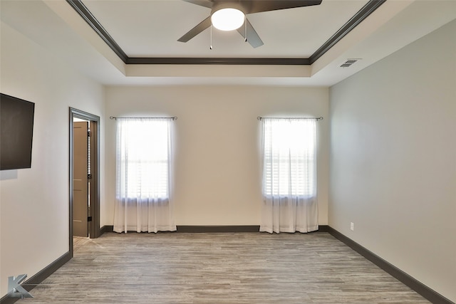 unfurnished room with a wealth of natural light, light wood-type flooring, and crown molding