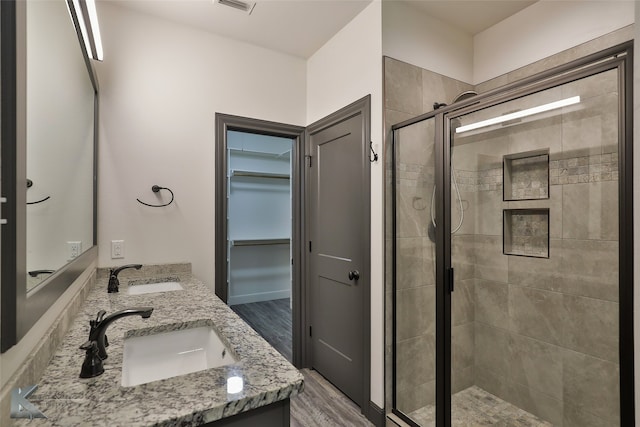 bathroom with vanity, hardwood / wood-style flooring, and a shower with door