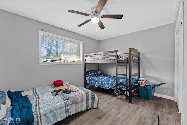 bedroom with ceiling fan, crown molding, and wood-type flooring