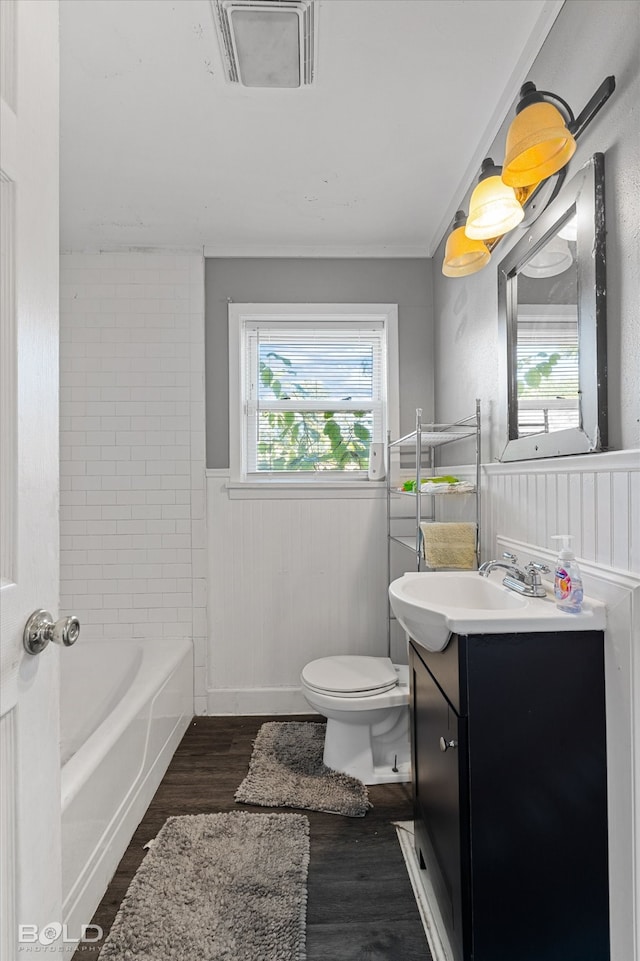 full bathroom with tiled shower / bath combo, toilet, vanity, and hardwood / wood-style floors