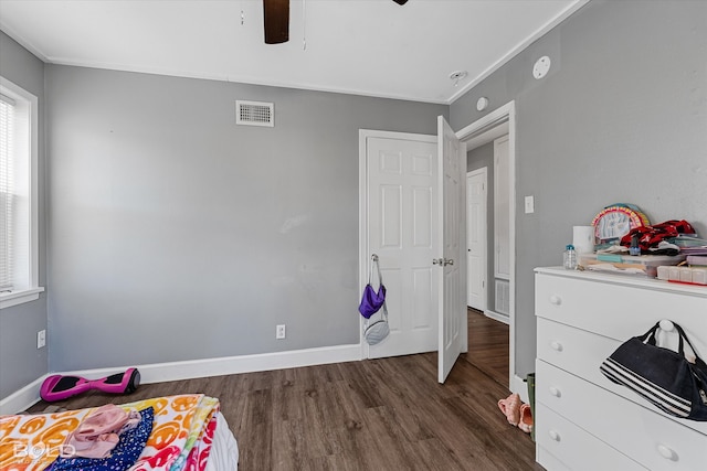 bedroom with ornamental molding, dark hardwood / wood-style floors, and ceiling fan