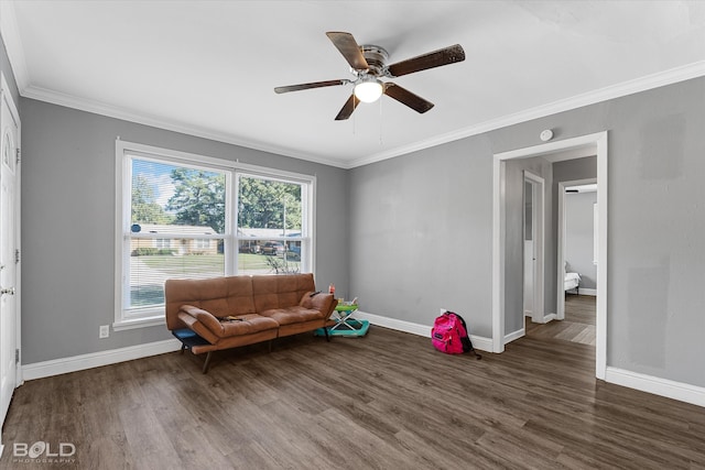 sitting room with ornamental molding, ceiling fan, and dark wood-type flooring