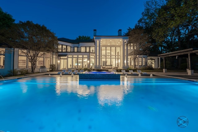 pool at night with a patio area