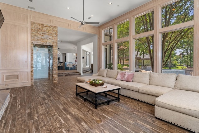 living room with ceiling fan, dark hardwood / wood-style floors, and a high ceiling