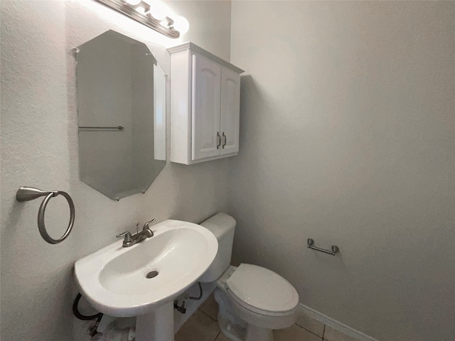 bathroom featuring toilet, sink, and tile patterned floors