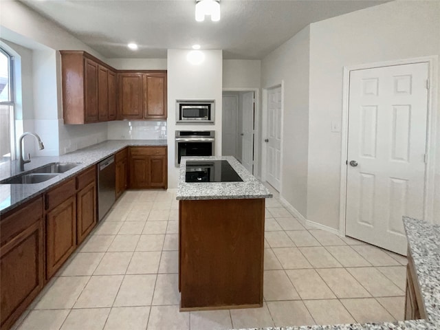 kitchen with light stone counters, a center island, light tile patterned flooring, sink, and stainless steel appliances