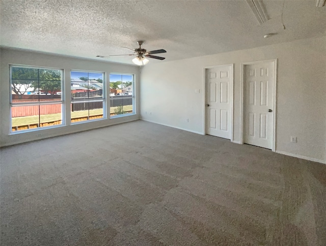 spare room with a textured ceiling, carpet flooring, and ceiling fan