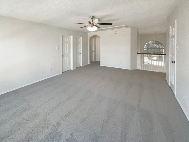 empty room featuring a textured ceiling, carpet, and ceiling fan