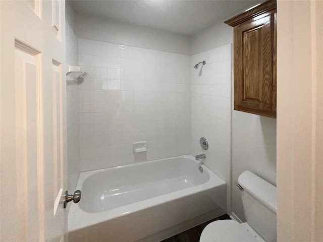 bathroom featuring tiled shower / bath and toilet