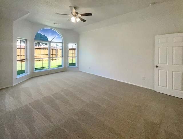 carpeted empty room with lofted ceiling, a textured ceiling, and ceiling fan