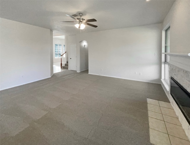 unfurnished living room featuring ceiling fan and carpet