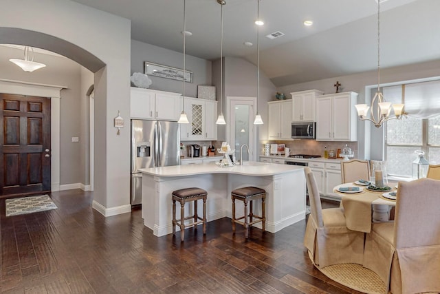 kitchen featuring white cabinetry, a center island with sink, appliances with stainless steel finishes, and dark hardwood / wood-style flooring