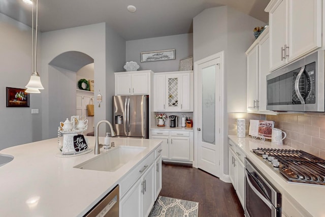 kitchen with decorative light fixtures, appliances with stainless steel finishes, sink, and white cabinets