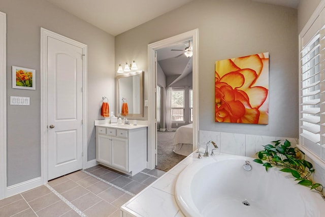 bathroom featuring tiled tub, vanity, ceiling fan, and tile patterned floors