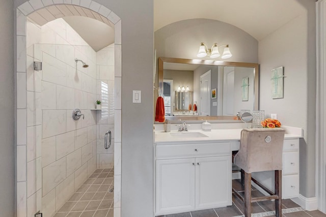 bathroom featuring walk in shower, vanity, lofted ceiling, and tile patterned flooring