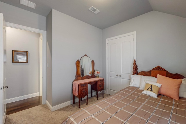 bedroom featuring carpet, vaulted ceiling, and a closet