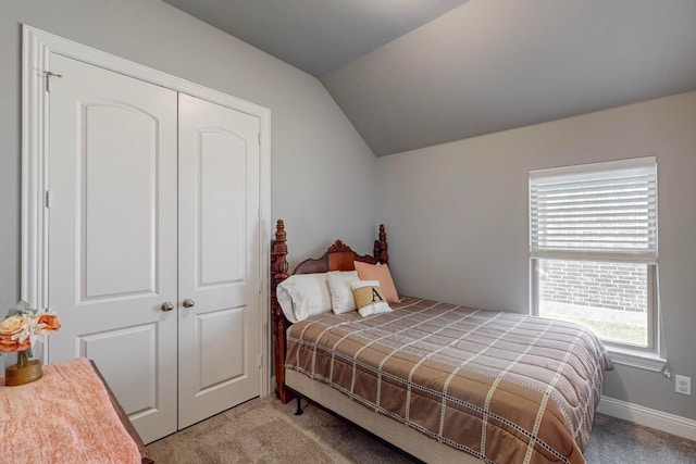 carpeted bedroom with a closet and vaulted ceiling