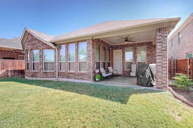 rear view of house with ceiling fan, a lawn, and a patio area