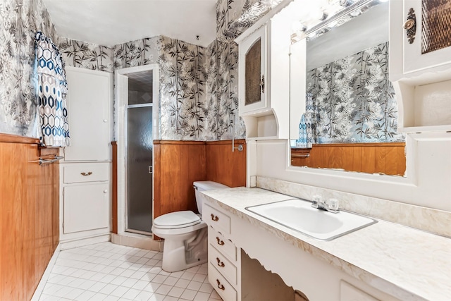 bathroom featuring tile patterned floors, vanity, wood walls, and toilet