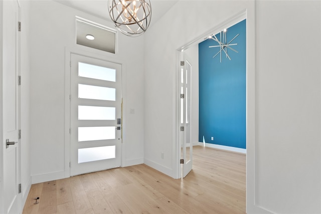 entryway featuring a wealth of natural light, light hardwood / wood-style floors, and a notable chandelier