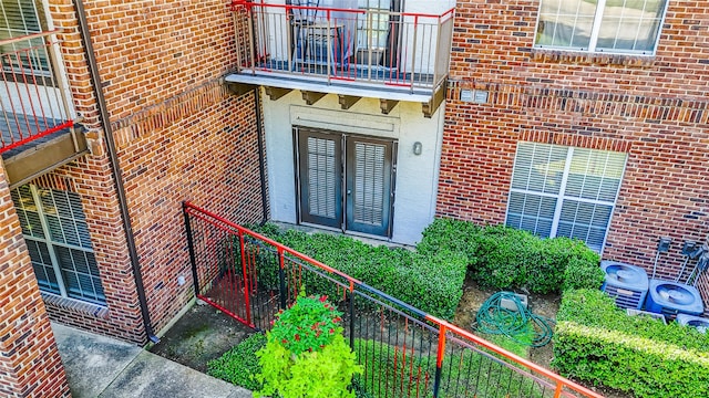 doorway to property with french doors, a balcony, and central AC