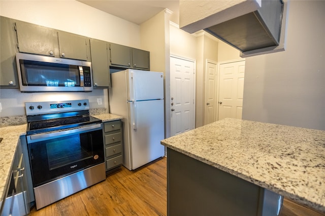 kitchen with light stone counters, light hardwood / wood-style floors, and appliances with stainless steel finishes