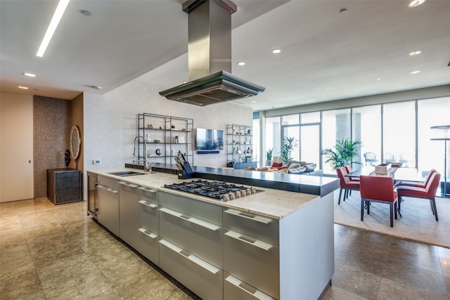 kitchen with a center island with sink, island range hood, gray cabinetry, and sink