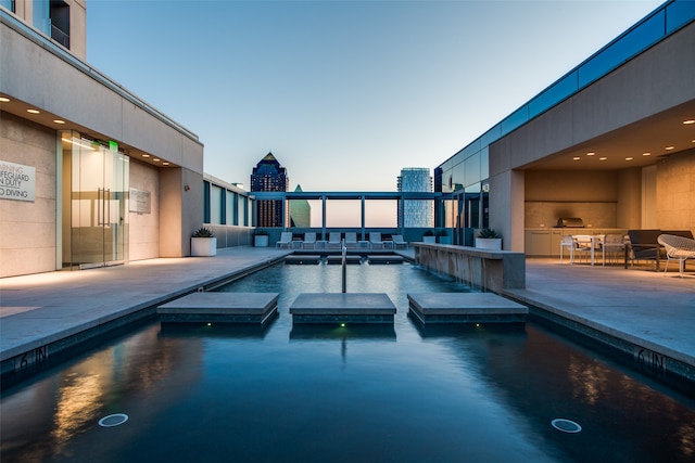 pool at dusk with a patio