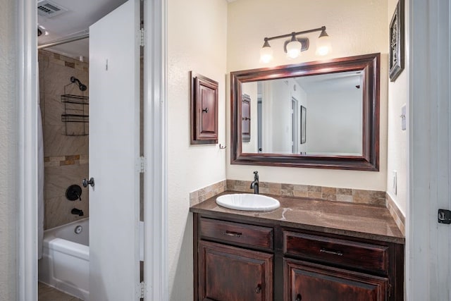 bathroom featuring tiled shower / bath combo and vanity