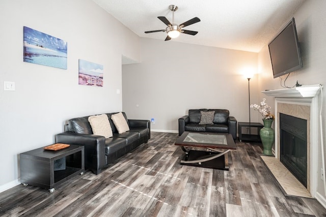 living room with a textured ceiling, ceiling fan, and dark wood-type flooring