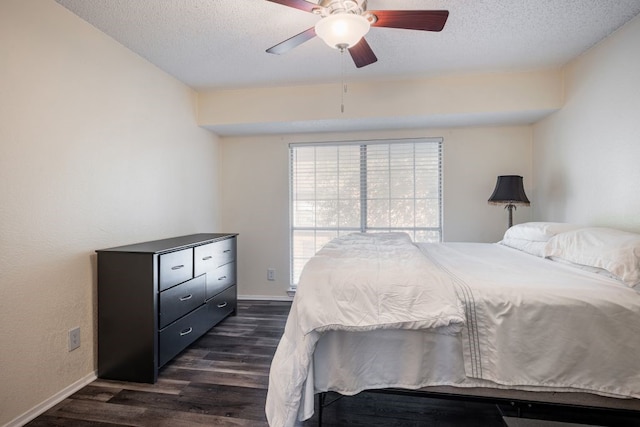 bedroom featuring ceiling fan, a textured ceiling, and dark hardwood / wood-style flooring