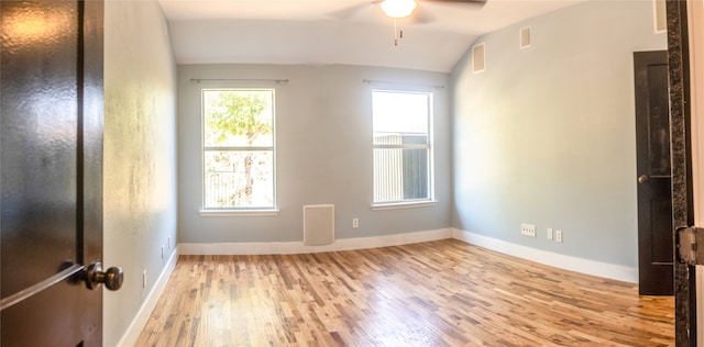 spare room featuring ceiling fan, vaulted ceiling, and light hardwood / wood-style flooring