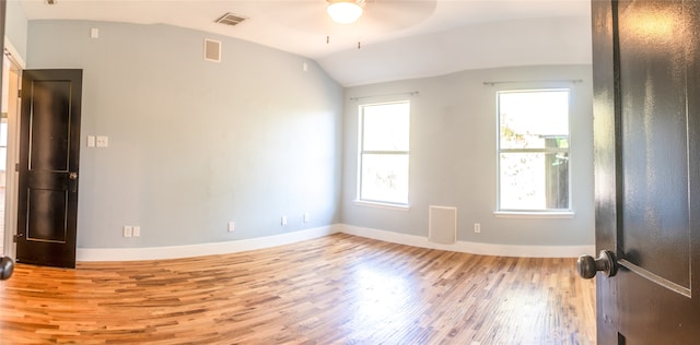 empty room with ceiling fan, light wood-type flooring, and lofted ceiling