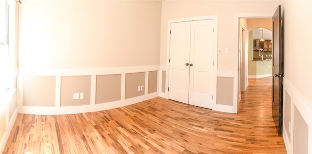 unfurnished bedroom with light wood-type flooring and a closet