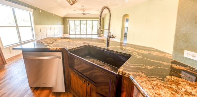 kitchen with ceiling fan, sink, kitchen peninsula, hardwood / wood-style flooring, and stainless steel dishwasher