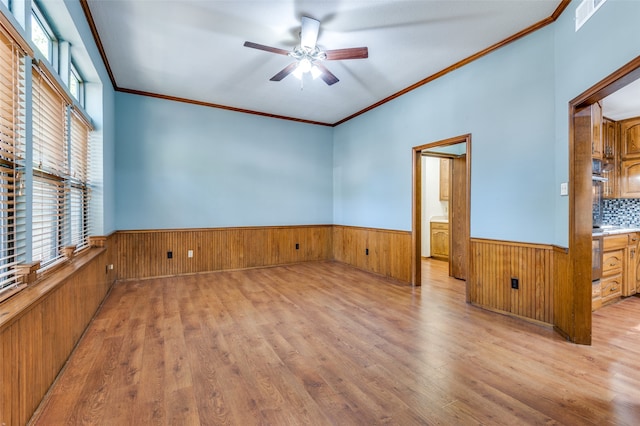 unfurnished room with ceiling fan, ornamental molding, and light hardwood / wood-style flooring