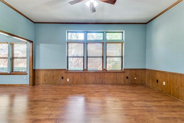 empty room featuring ceiling fan, wood-type flooring, and ornamental molding